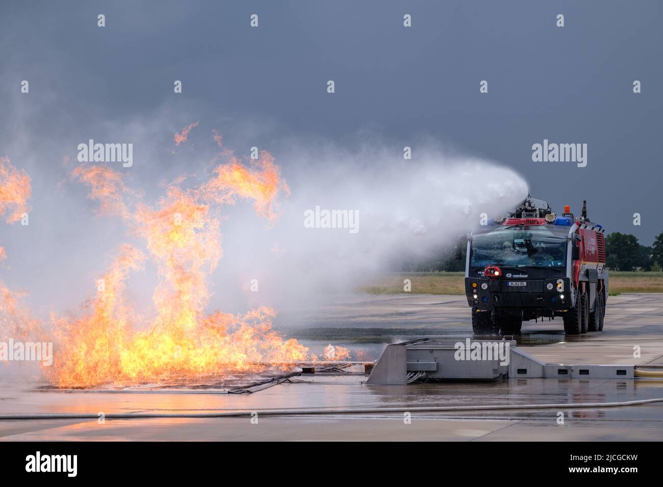 Langenhagen, Germany. 13th June, 2022. Airport firefighters extinguish a wildfire at Hannover Airport during an exercise at the mobile fire simulation facility. The facility is a joint project of Hannover, Stuttgart and Bremen airports and is intended to serve the training and exercise of airport firefighters. Credit: Ole Spata/dpa/Alamy Live News Stock Photo