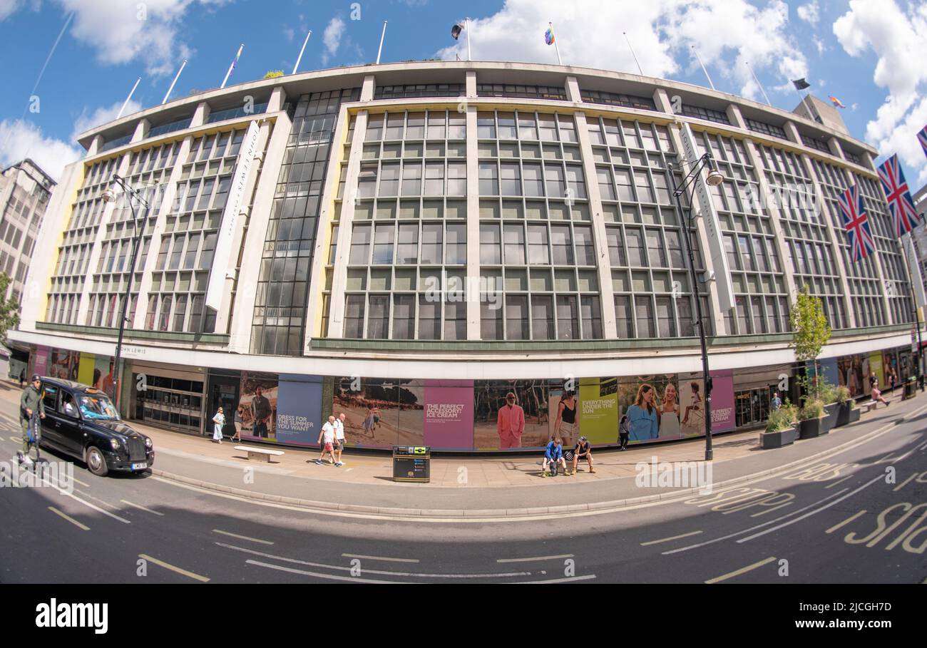 Oxford Street, London, UK. 13 June 2022. Platinum Jubilee flags hang above Oxford Street on a warm day in this fisheye lens view of the John Lewis and Partners flagship store. Credit: Malcolm Park/Alamy Live News. Stock Photo
