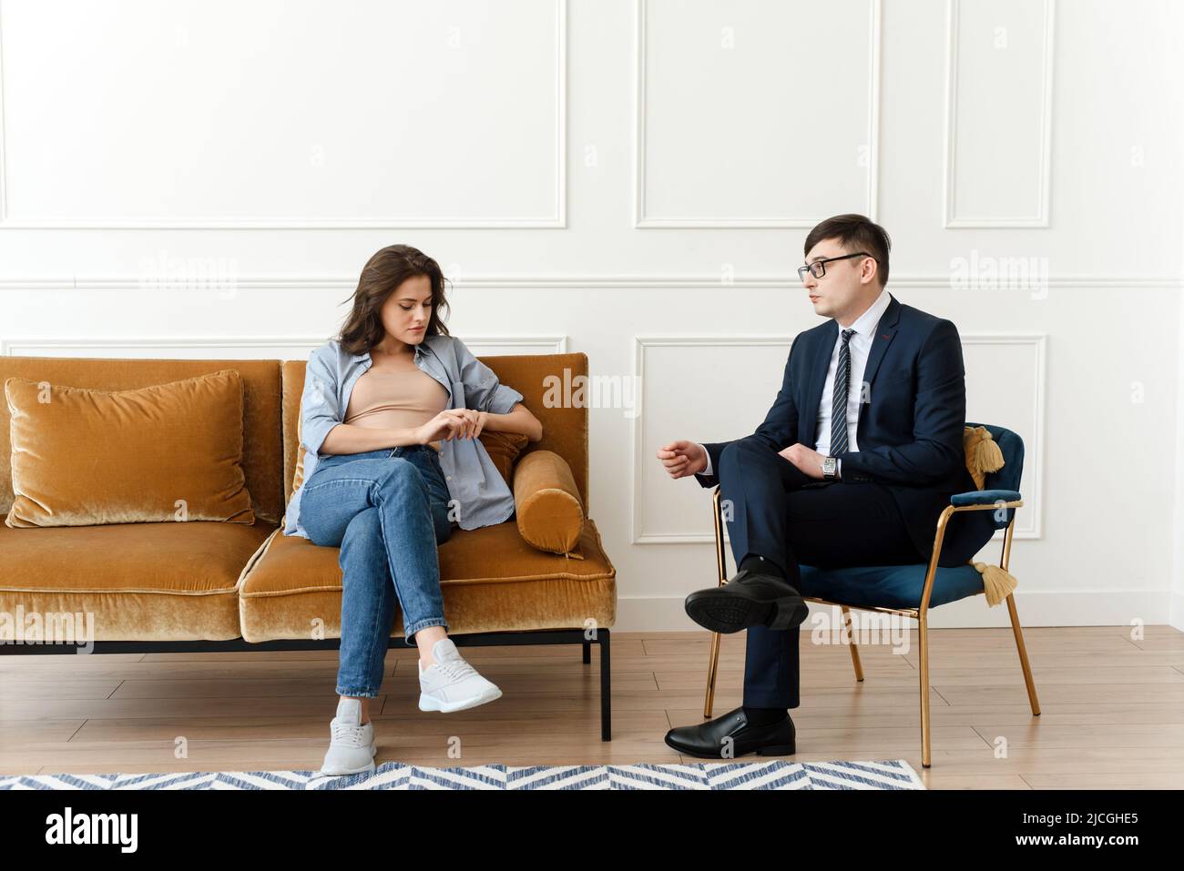 Woman patient with male psychologist consulting and doing psychotherapy with doctor in clinic. Psychiatrist concept Stock Photo