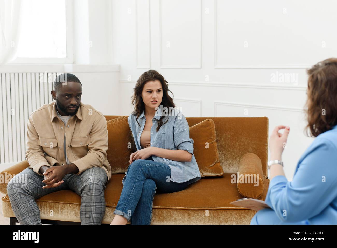 Diverse couple talking to psychologist woman about relationship problems. Marital Therapy. Family Reconciliation. Stock Photo