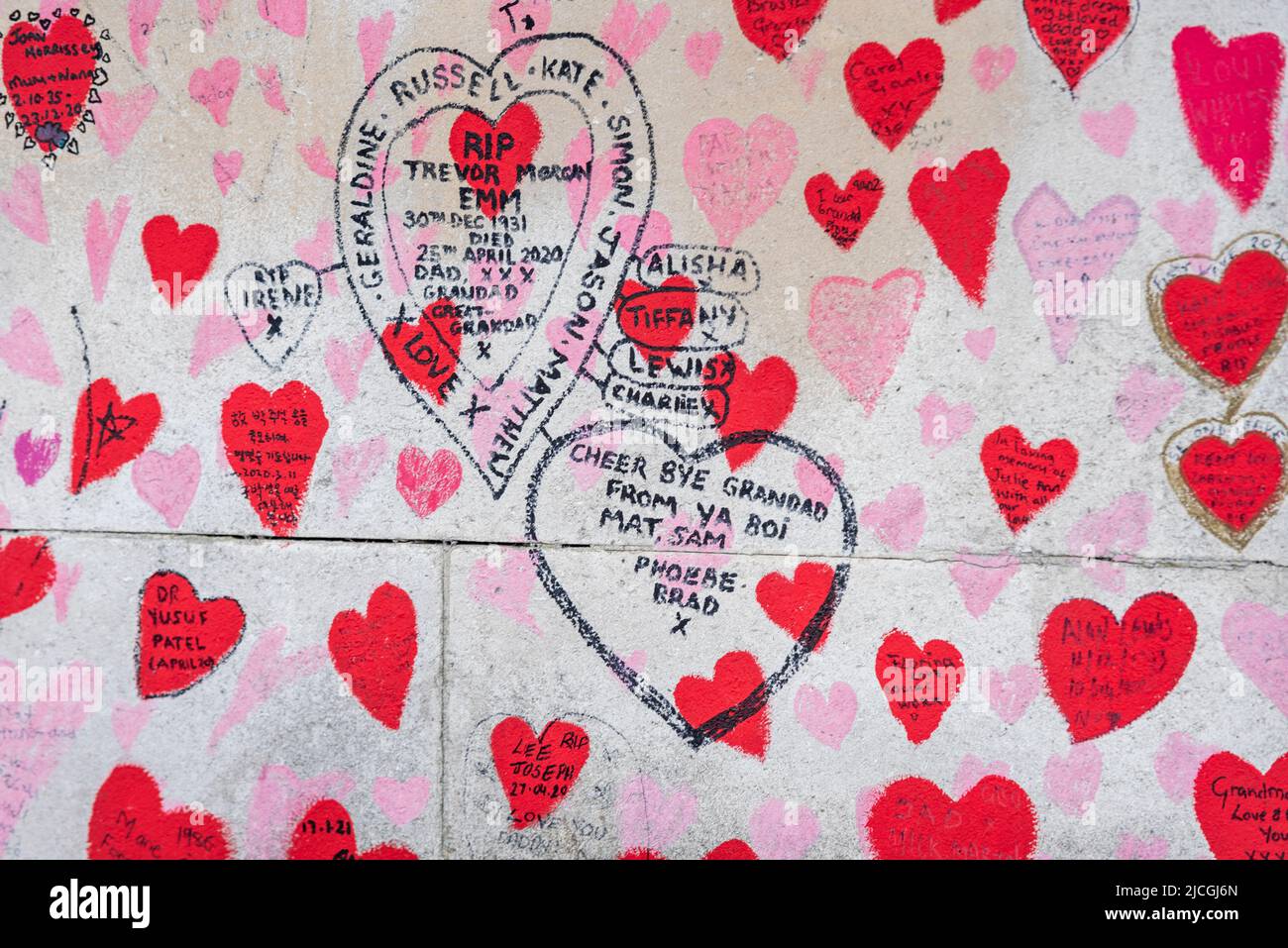 National Covid Memorial Wall in Lambeth, London, UK. Red hearts drawn onto a wall representing each death from COVID 19, with added names. Stock Photo