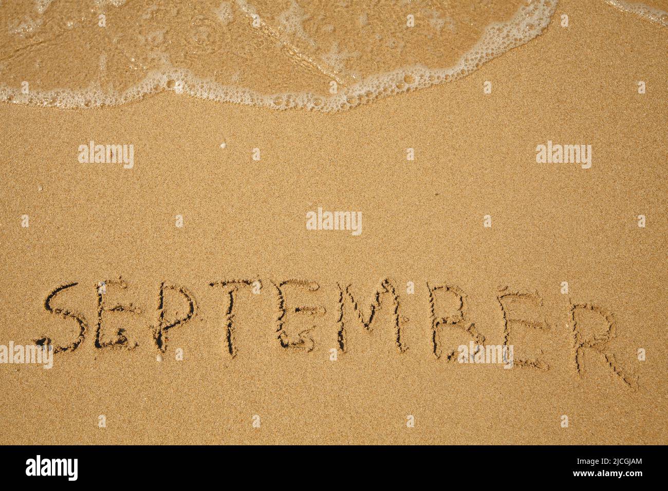 September - handwritten on the soft beach sand Stock Photo - Alamy
