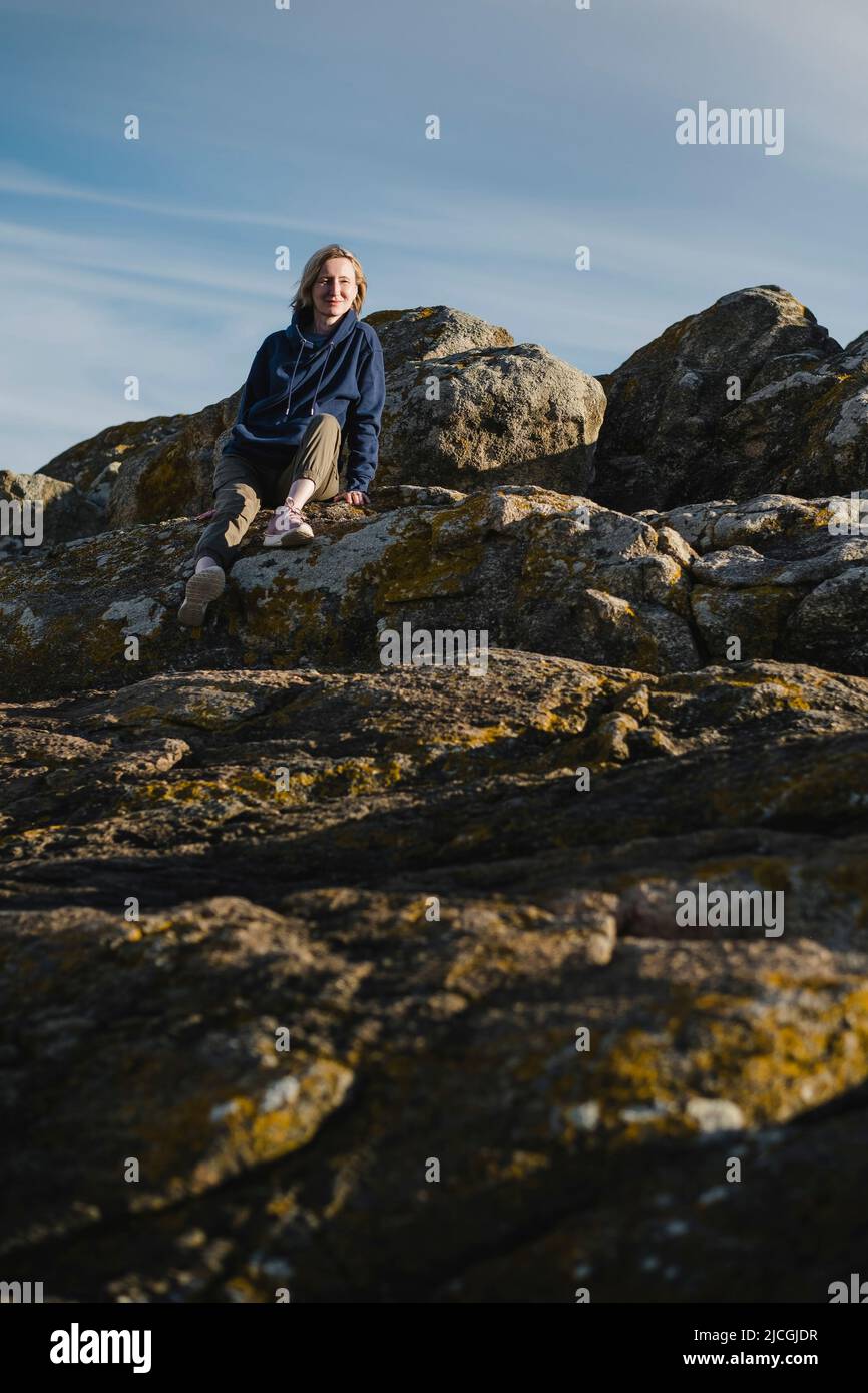 Beautiful woman sits on cliff hi-res stock photography and images - Alamy