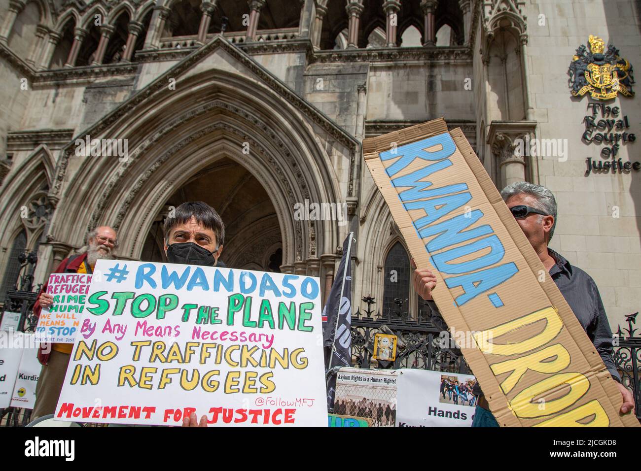 London, UK. 13th June, 2022. Demonstrators hold placards expressing their opinion during the protest outside the Royal Courts of Justice whilst a legal case is heard over halting planned deportation of asylum seekers from Britain to Rwanda. The government's immigration policy of deporting asylum seekers to Rwanda faces two legal challenges as campaigners seek to appeal a High Court ruling that gave the go-ahead to the first flight on Tuesday. Credit: SOPA Images Limited/Alamy Live News Stock Photo