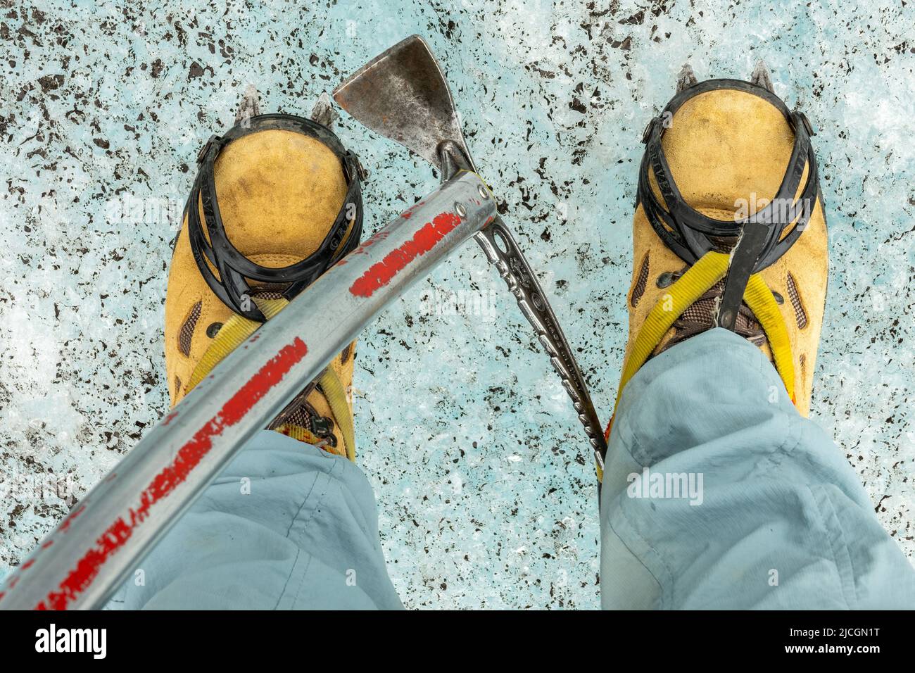 Detail of shoes with crampons and ice axe. Glacier walk in Iceland Stock Photo