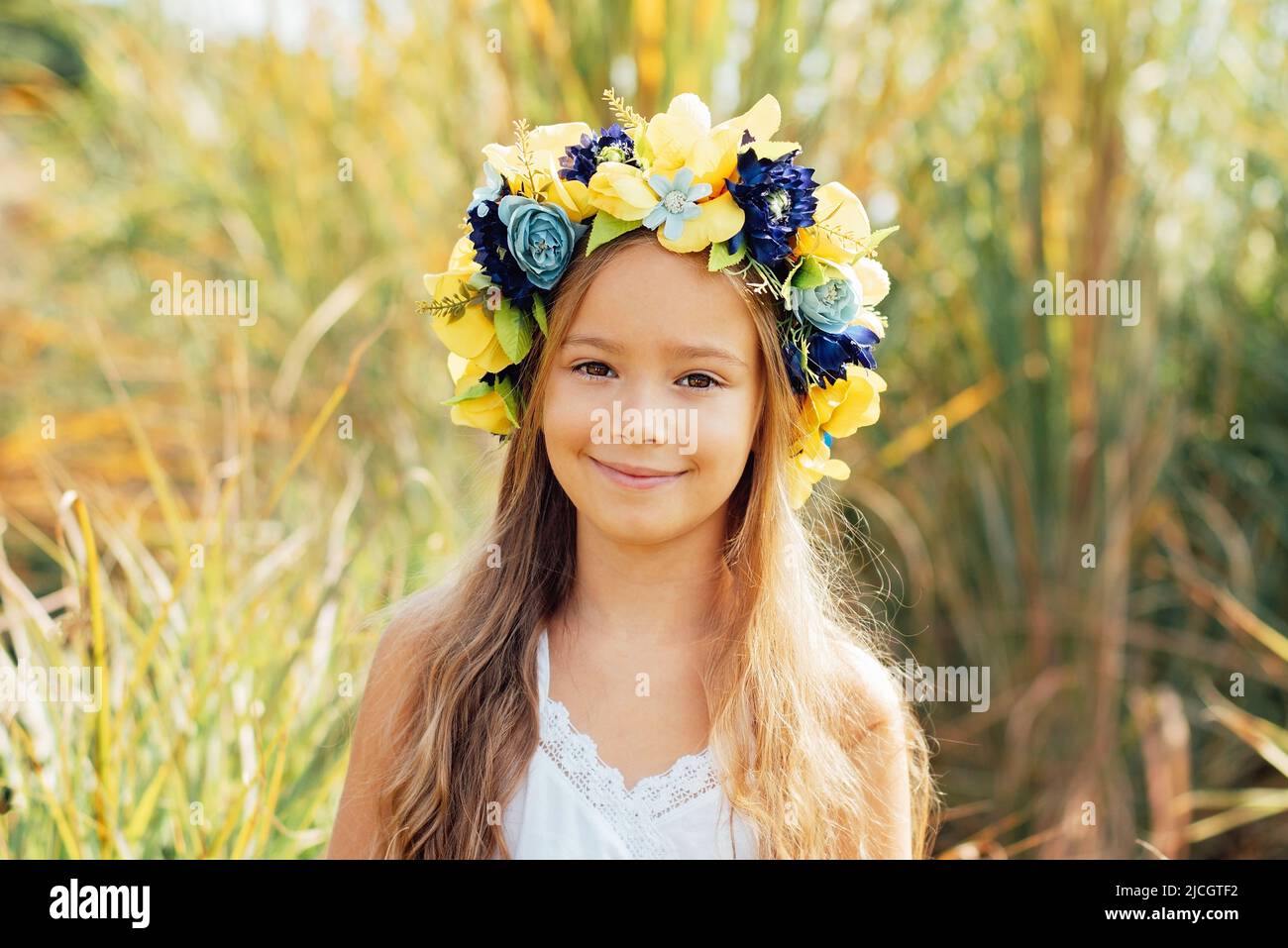 Portrait of happy Ukrainian child girl with yellow and blue flag of Ukraine. flag symbols of Ukraine. Family, unity, support. Ukrainians are against war. Stock Photo