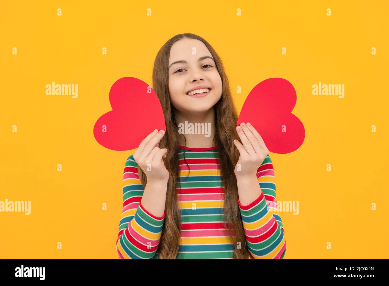 Lovely child girl 12, 13, 14 years old with shape heart love holiday and valentine symbol. Valentine or birthday day. Stock Photo