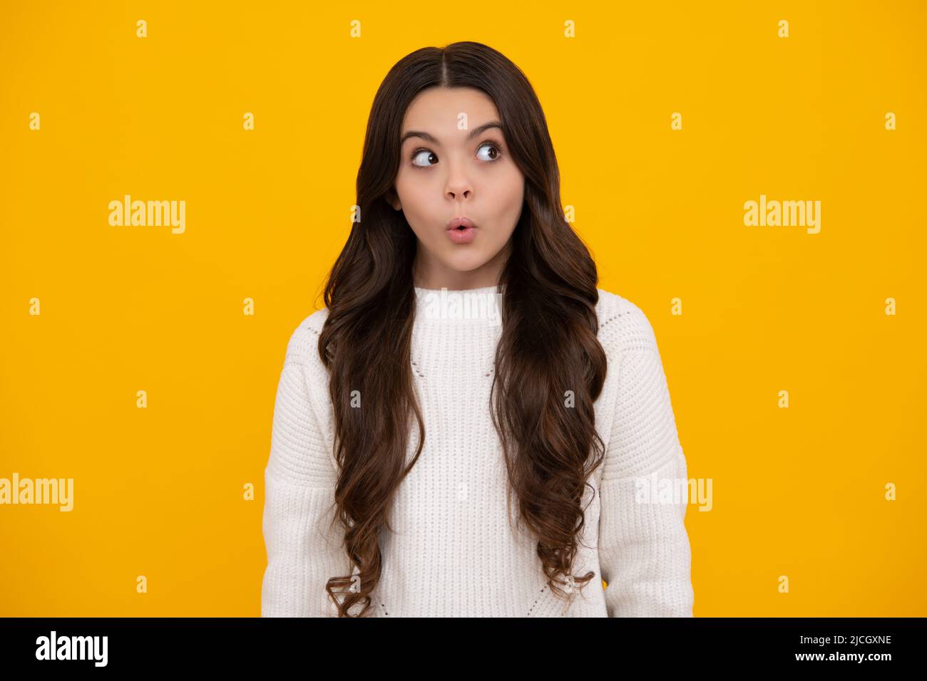 Teenager child girl with shocked facial expression. Surprised face expression, isolated on yellow background. Funny surprise. Surprised teenager girl. Stock Photo