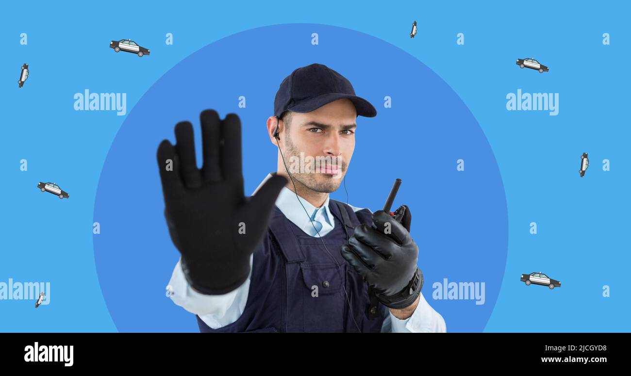 Portrait of young caucasian policeman with walkie-talkie gesturing stop sign on blue background Stock Photo