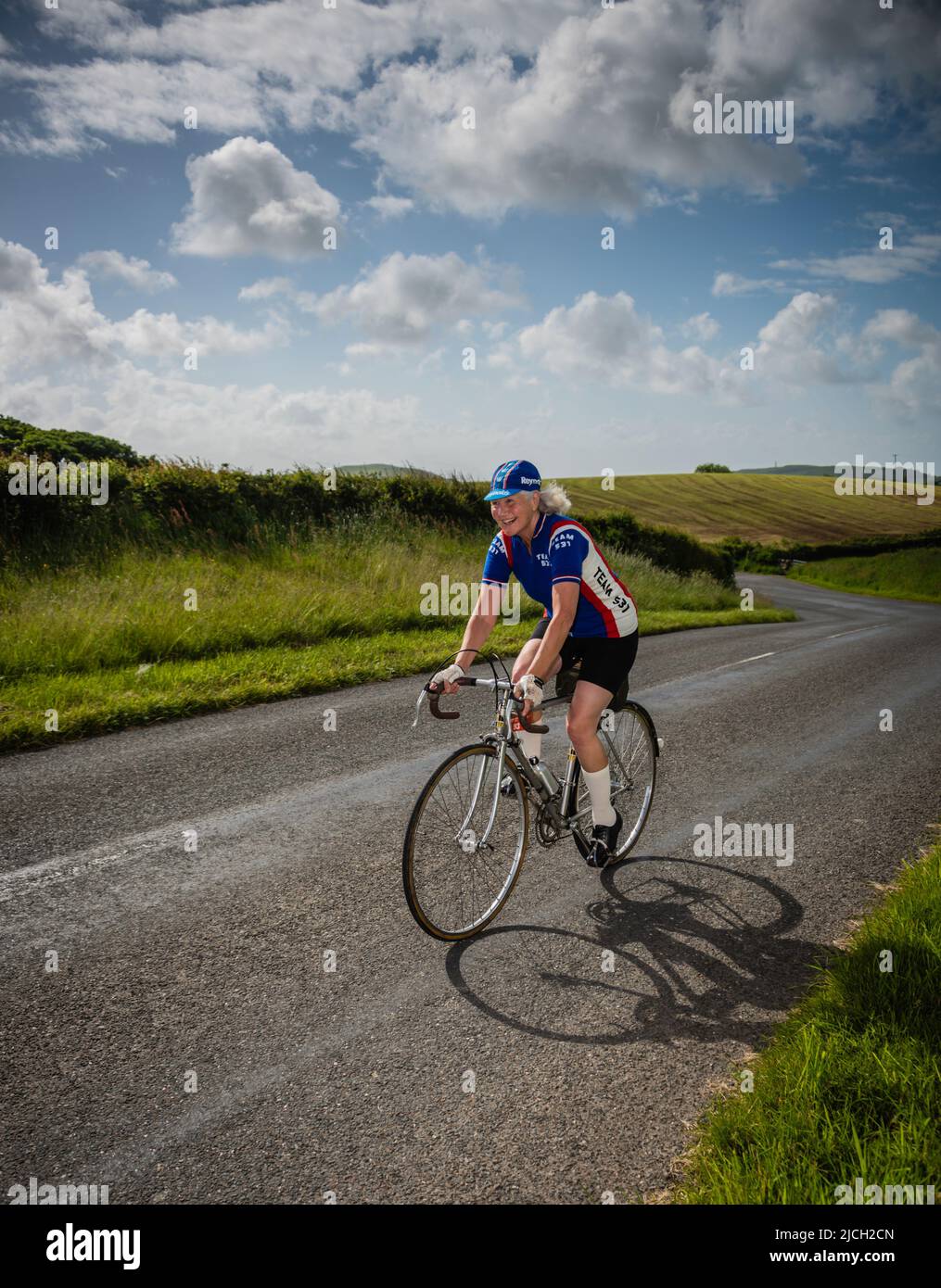 Mature female road cyclist in the Veloretro vintage cycling event, Ulverston, Cumbria, UK. Stock Photo