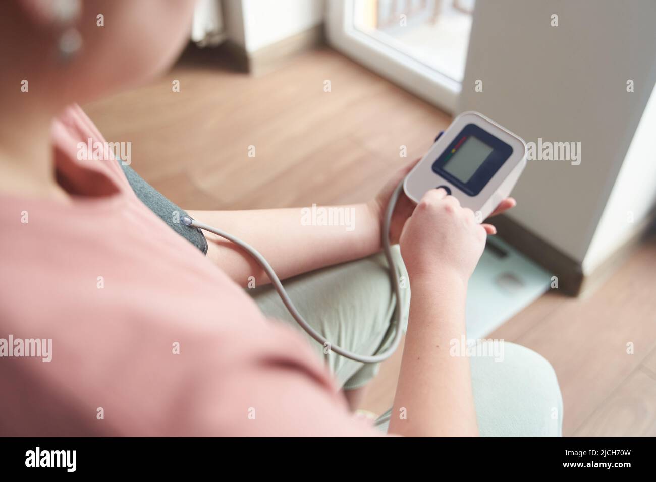 a young girl measures her blood pressure with a tonometer  Stock Photo