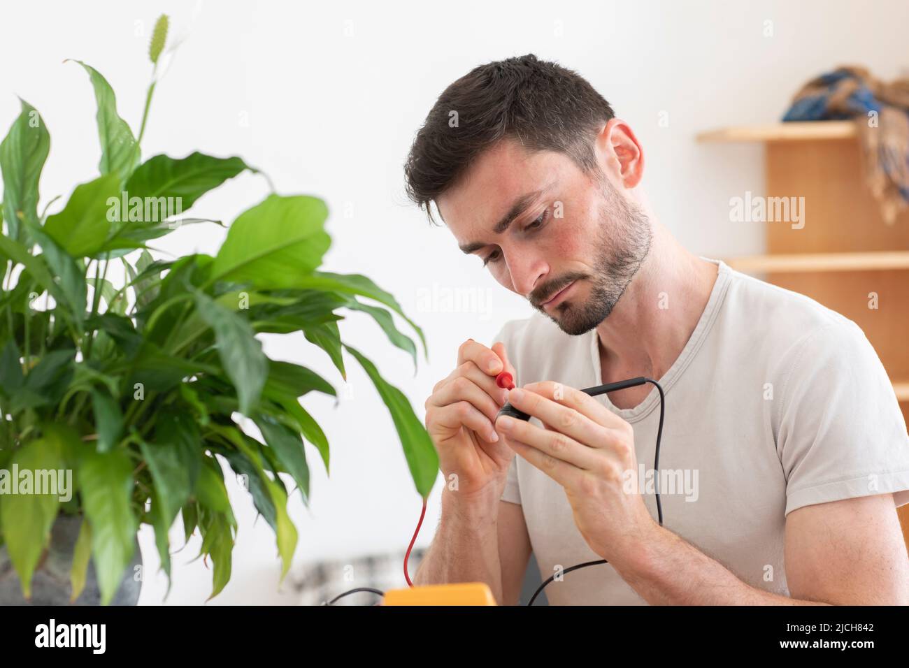 young man working sustained in a room with plant Stock Photo
