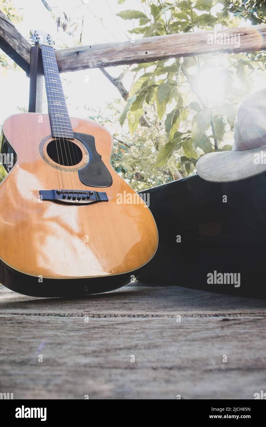 guitar on wood plus a saxophone case and hat Stock Photo