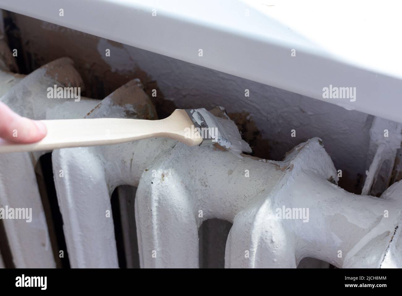 Painting radiators with a special brush. Battery painting Stock Photo