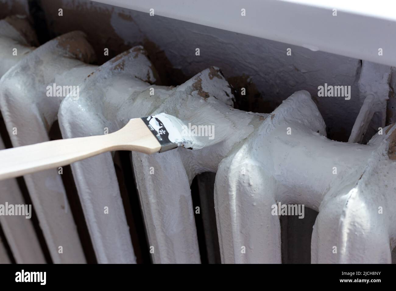 Painting radiators with a special brush. Battery painting Stock Photo