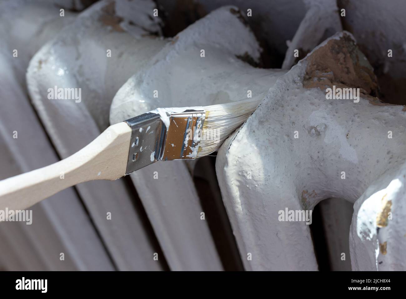 Painting radiators with a special brush. Battery painting Stock Photo