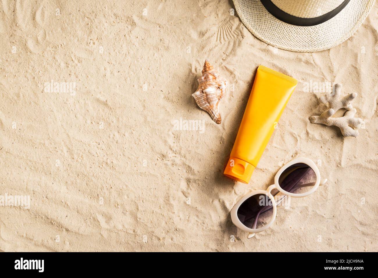 Sunscreen lotion on sandy beach as background, top view, copy space. Summer vacation and skin care concept, spf uv-protect cosmetic products. Stock Photo