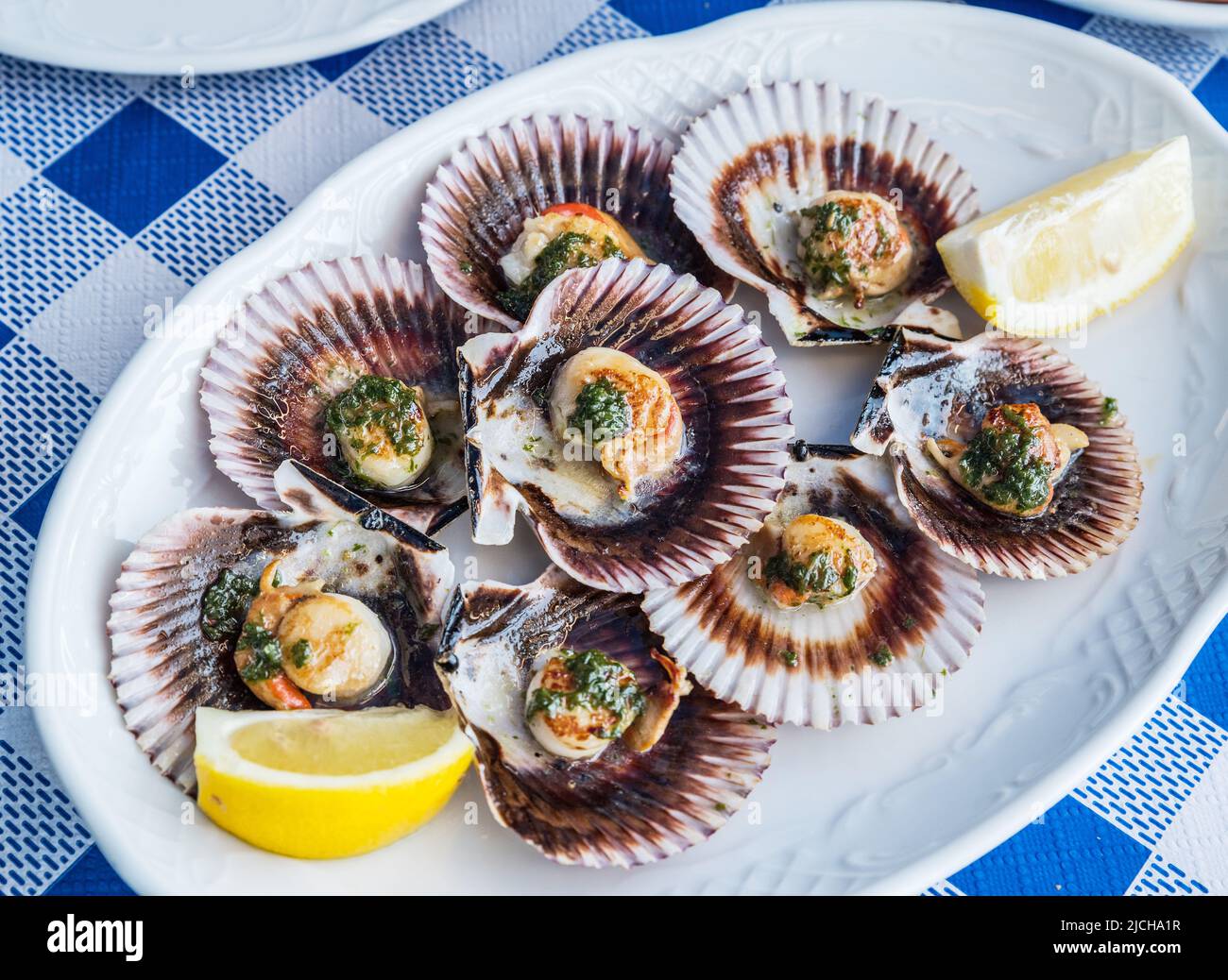 'Lapas' or true limpets with green moyo - traditional seafood of Tenerife and Madeira Islands. Stock Photo