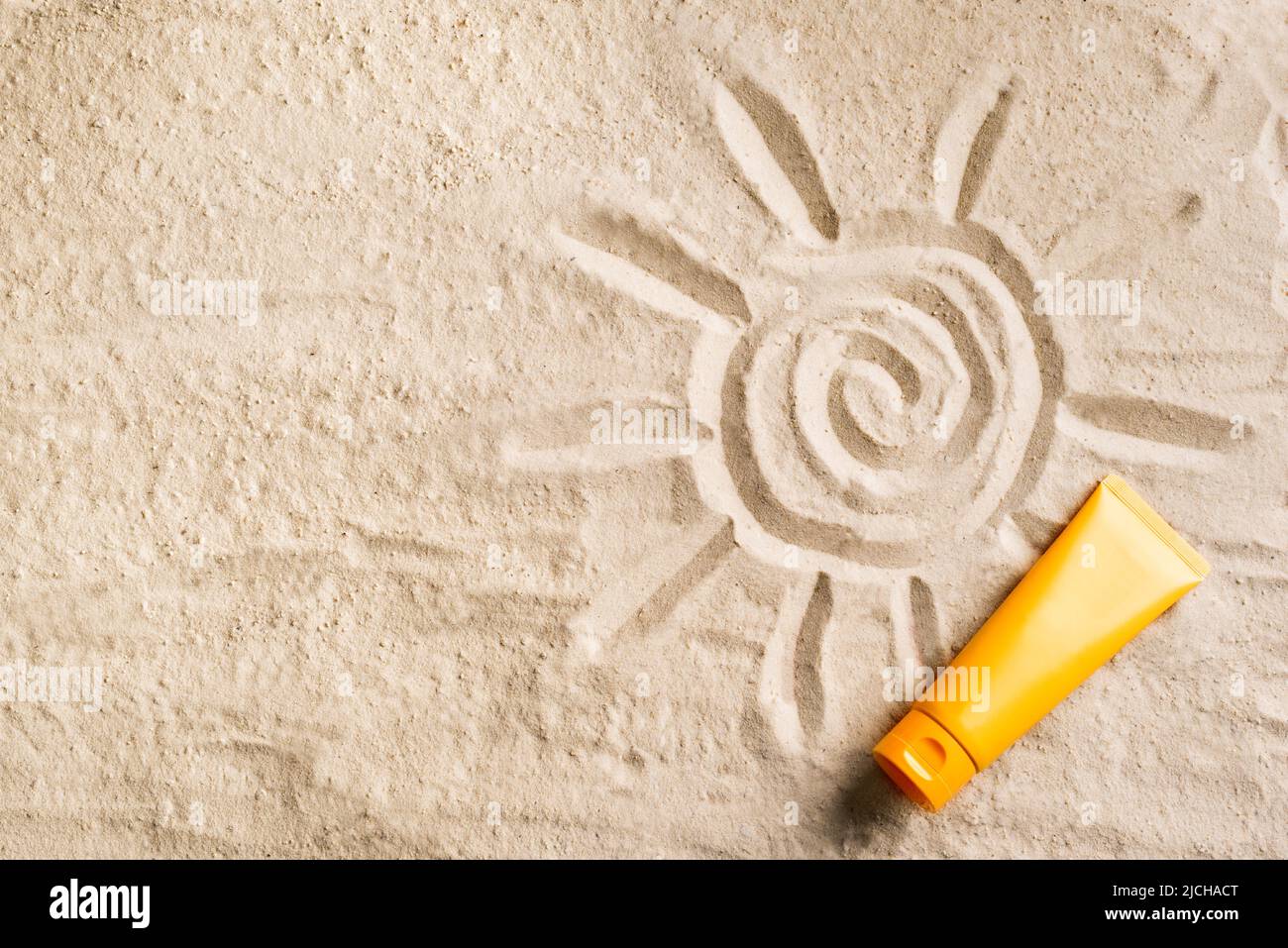 Sunscreen lotion on sandy beach as background, top view, copy space. Summer vacation and skin care concept, spf uv-protect cosmetic product tube. Stock Photo
