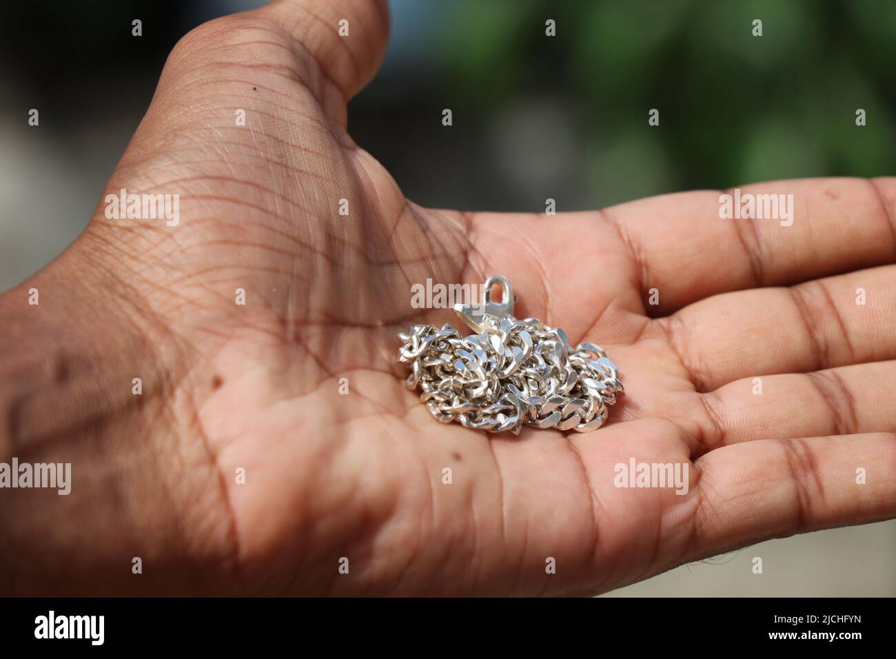 Silver chain or silver necklace is a fashion accessory held in the hand ...