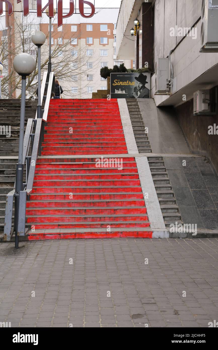 Red stairs, lined with light poles, lead to a sign with Frank Sinatra on it; in the streets in the center of Minsk, Belarus Stock Photo
