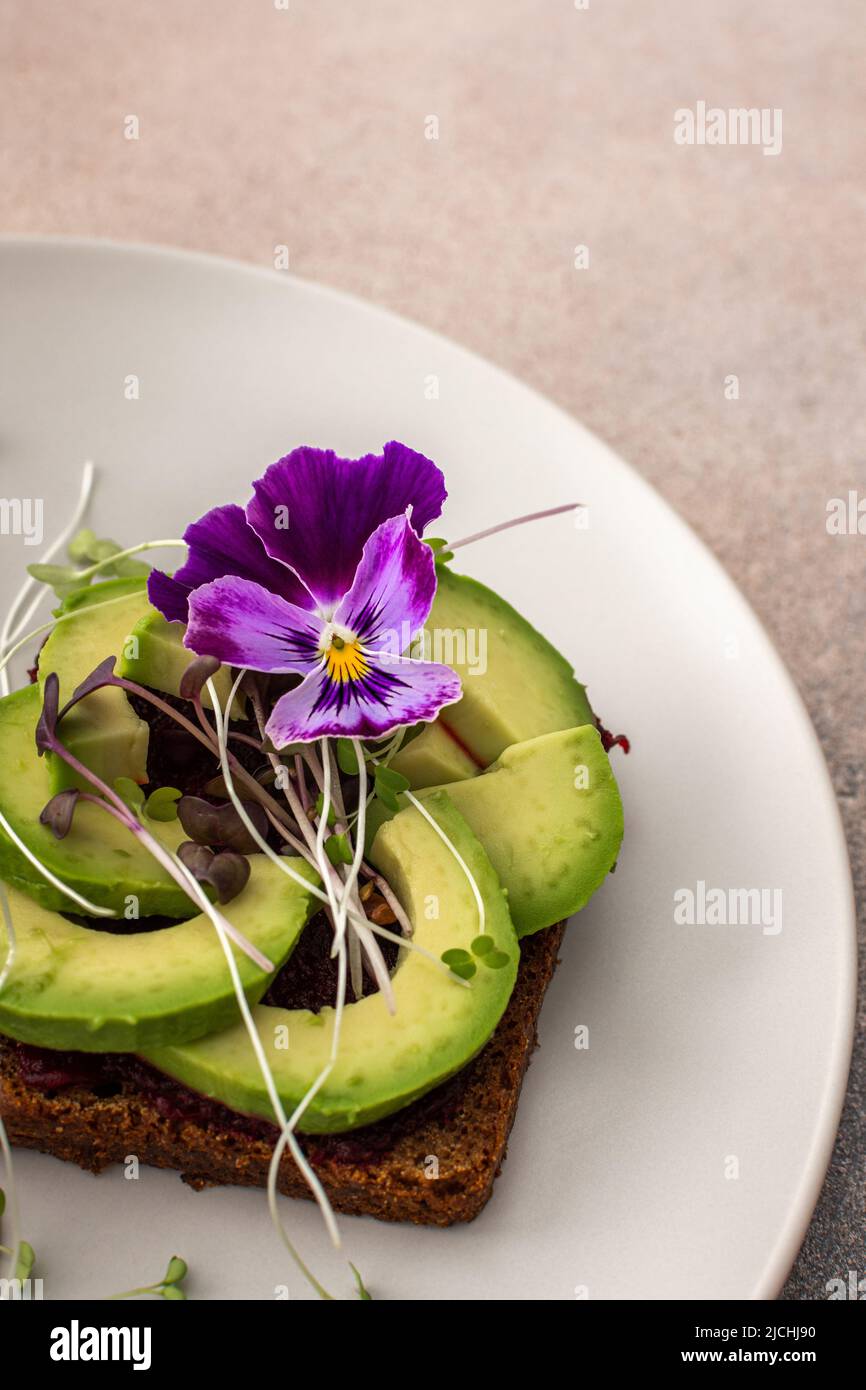 Sandwiches with boiled beetroot and avocado with microgreens, delicious healthy breakfast Stock Photo