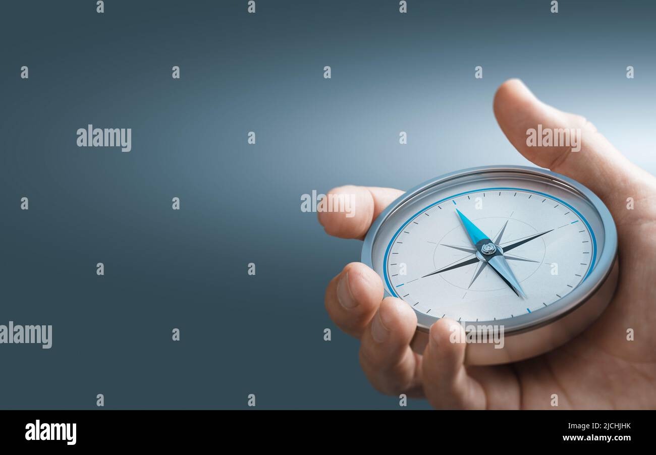 Hand holding a compass over blue background with copy space. Concept of Strategic orientation in business or marketing. Composite image between a 3d i Stock Photo