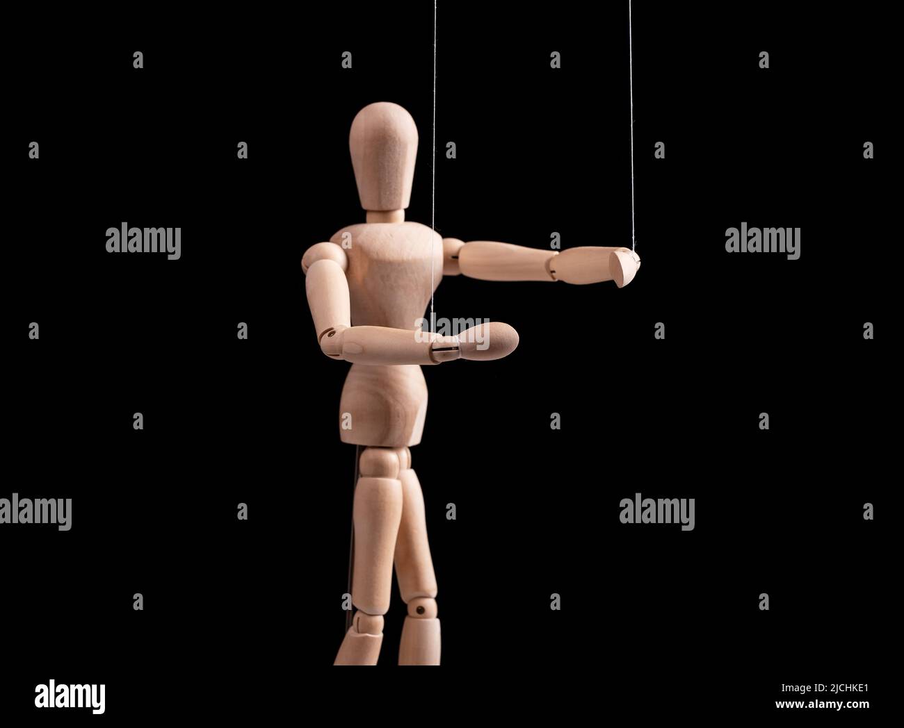 Puppet on strings. Manipulation, control, power, abuse concept. Marionette in human hand. High quality photo Stock Photo