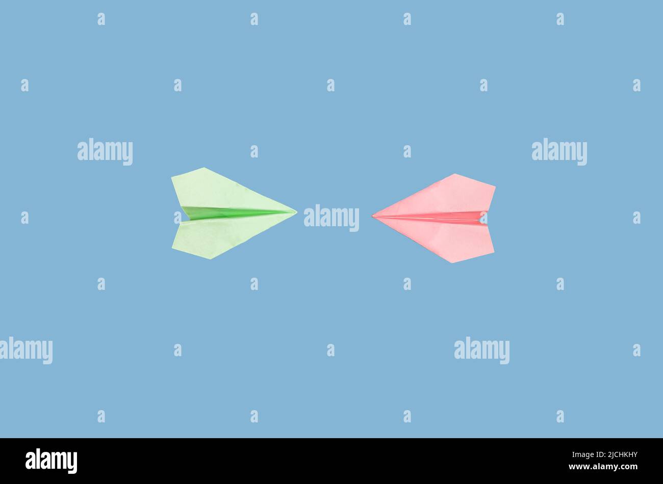 Confrontation, collision concept. Origami planes flying towards each other on blue background. Conflict of interest. High quality photo Stock Photo