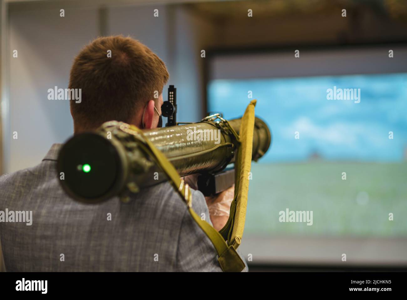 A man aims from a grenade launcher . Airsoft grenade launcher Stock