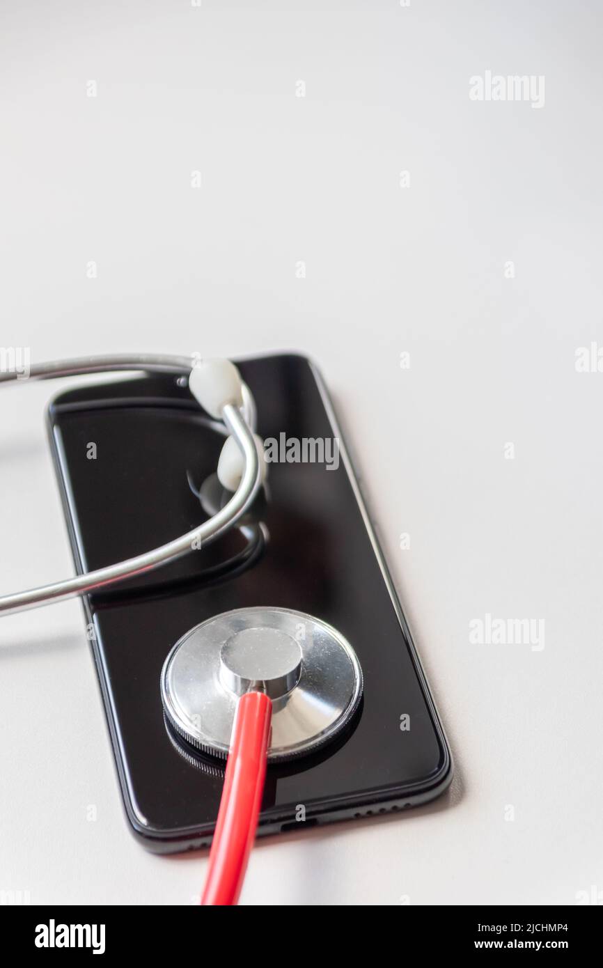Red stethoscope on black smartphone represents health records and digital patient records with mobile devices for digital doctors digital diagnostic Stock Photo