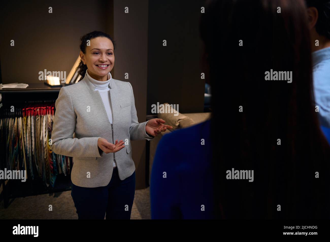 Sales manager, retail consultant of a furniture store standing against