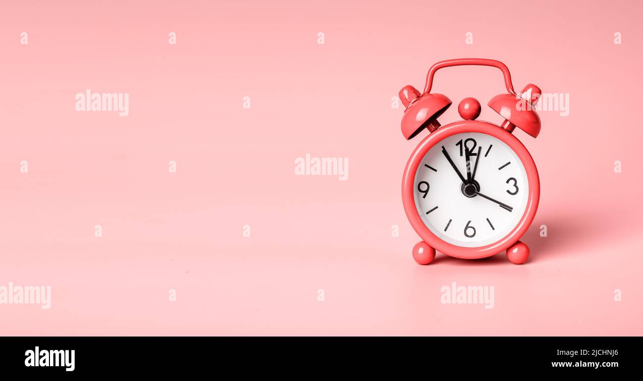 Retro alarm clock on coral colored banner with copy space for text. High quality photo Stock Photo
