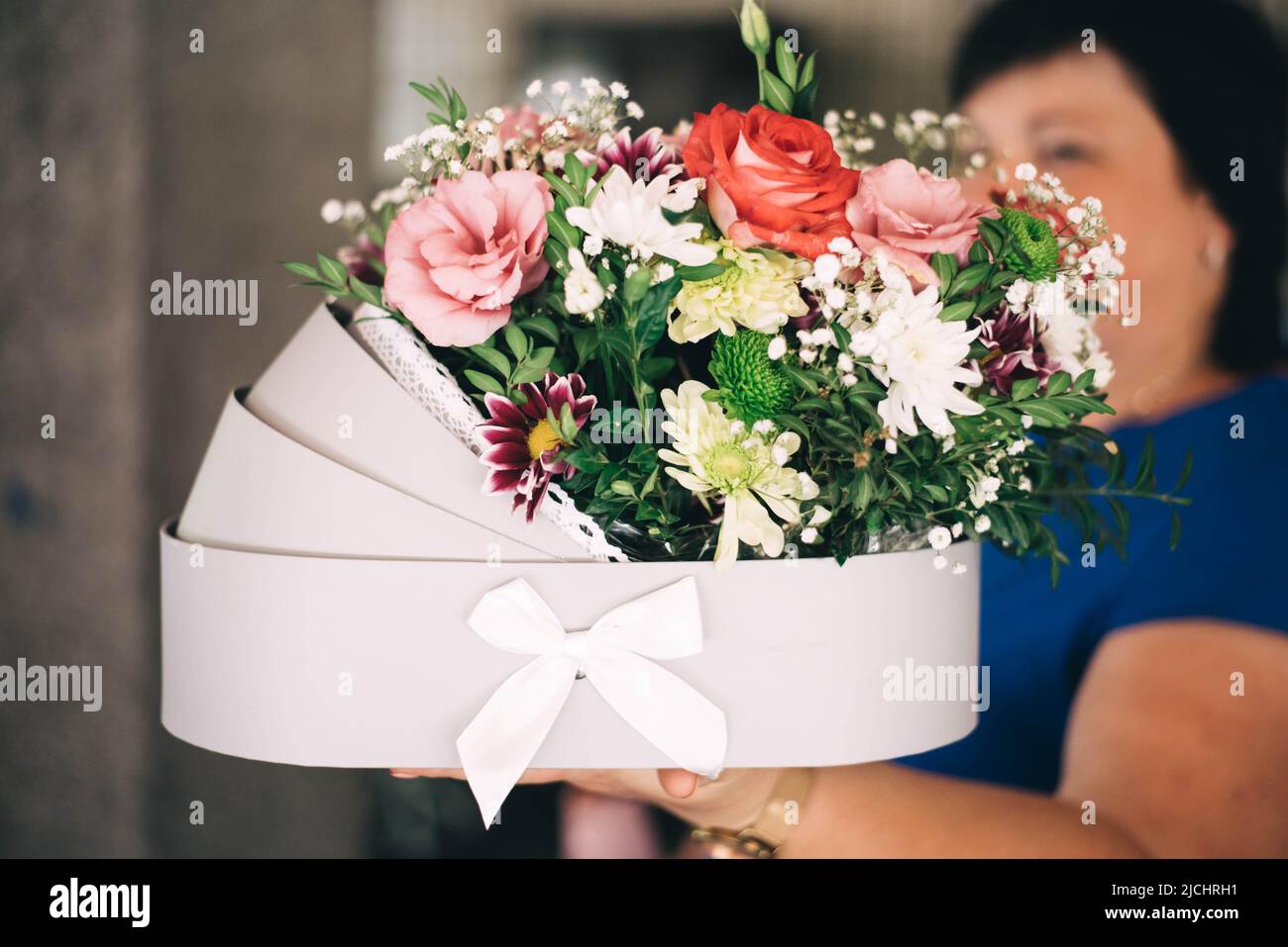 Woman holding a bouquet of flowers for a newborn baby. High quality photo Stock Photo