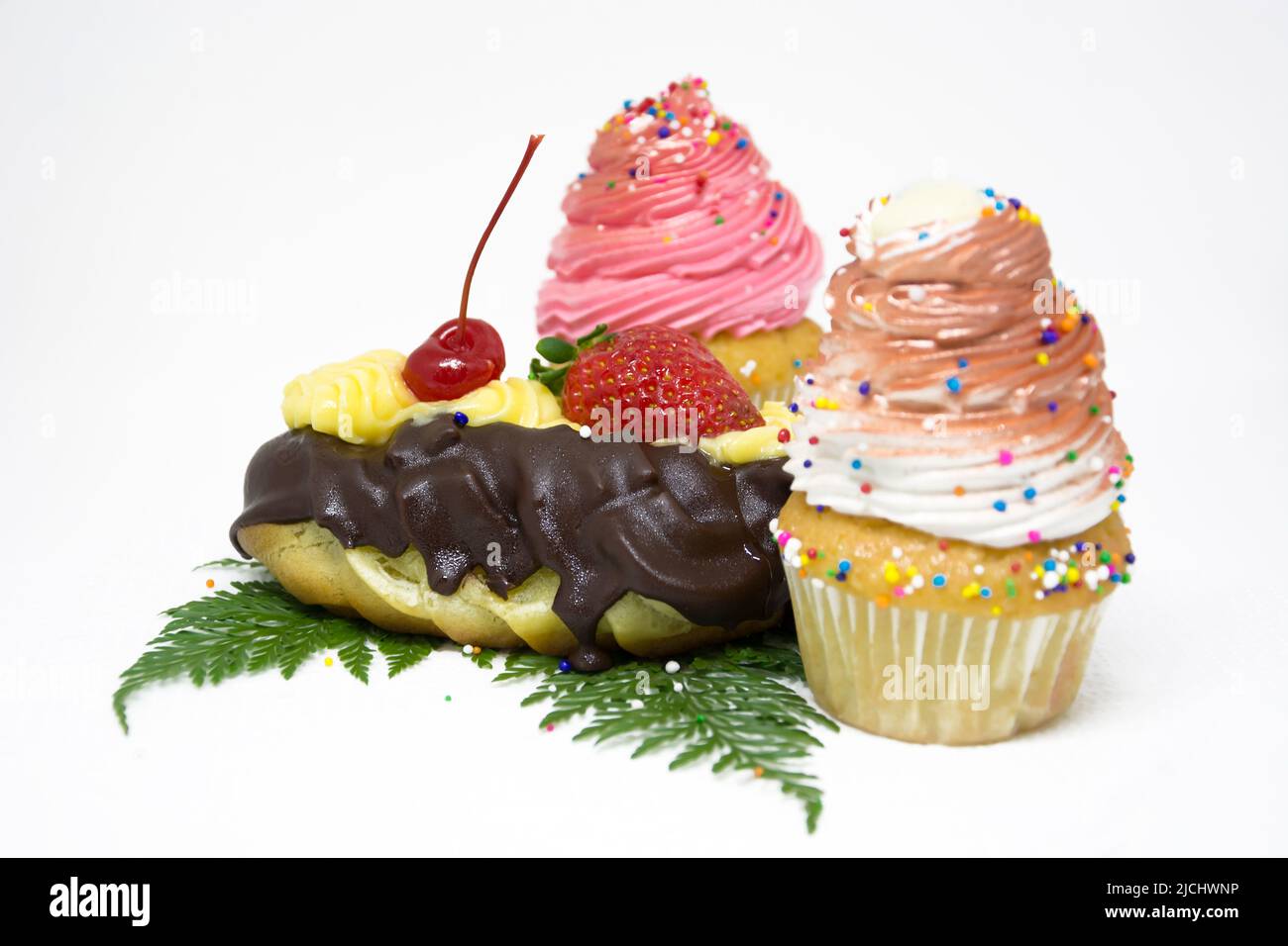 Small cake baked in a cupshaped container and typically iced Stock
