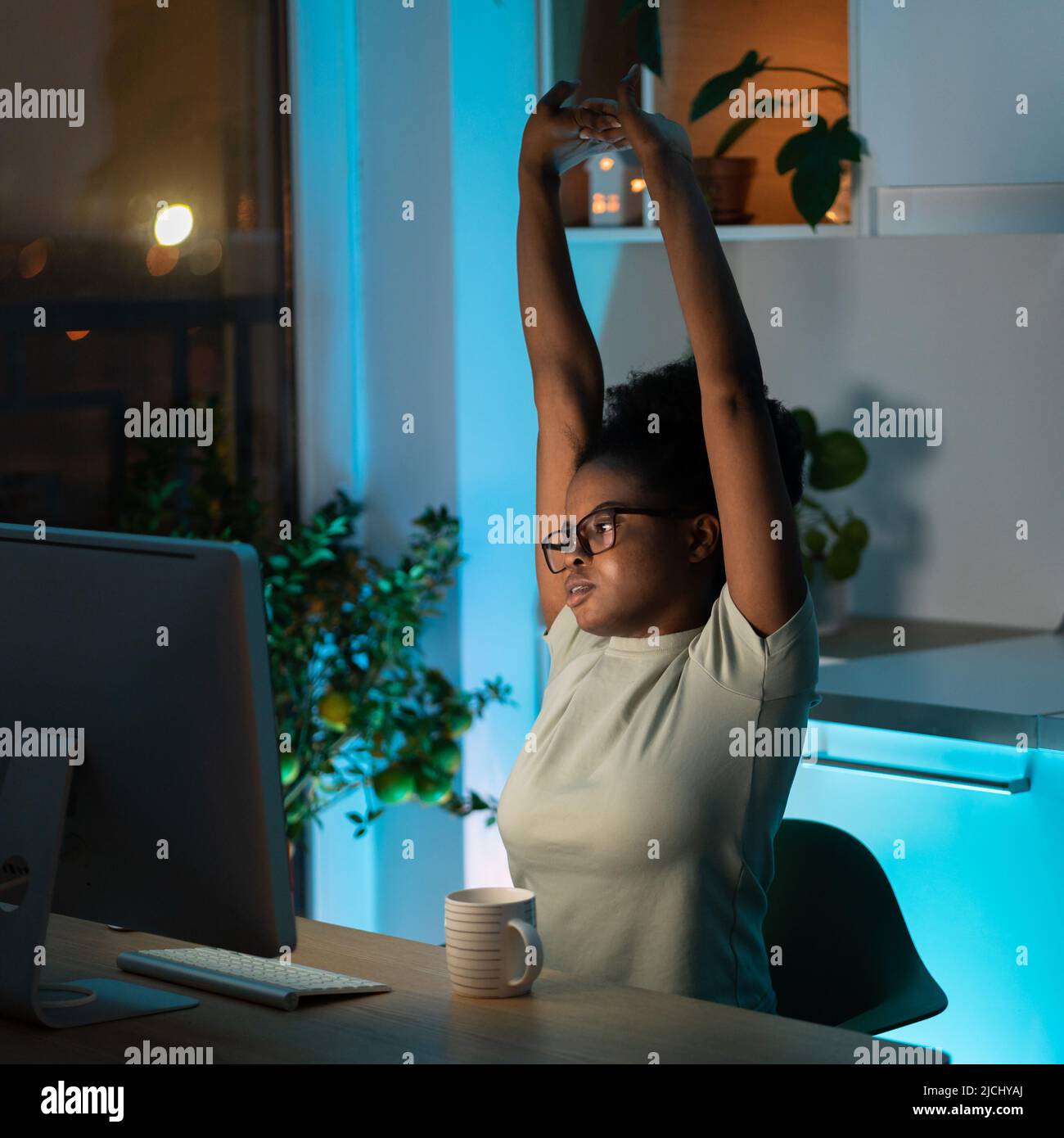 Tired African young woman takes a break from work on computer at home ...