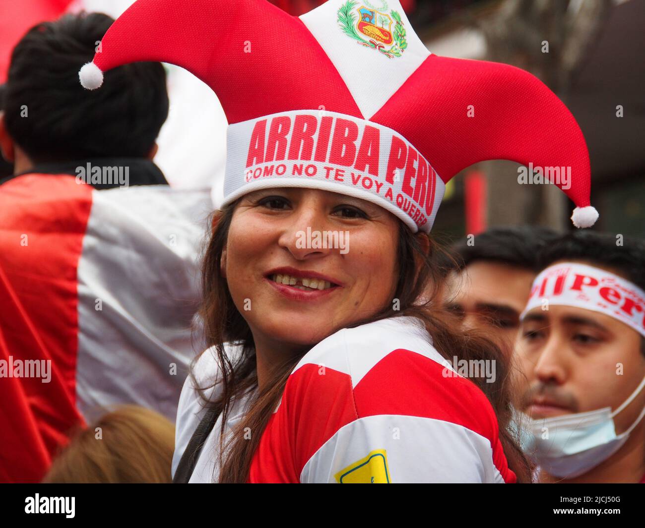 A woman wearing the colors of the Peruvian national team when fans of the Peruvian Football team watching the Qatar 2022 FIFA World Cup Peru vs. Australia match in a giant TV screen installed at the street in Miraflores district. Peru plays against Australia in a playoff match to get a place in Qatar Football World Championship 2022. Australia won the match on penalties Stock Photo