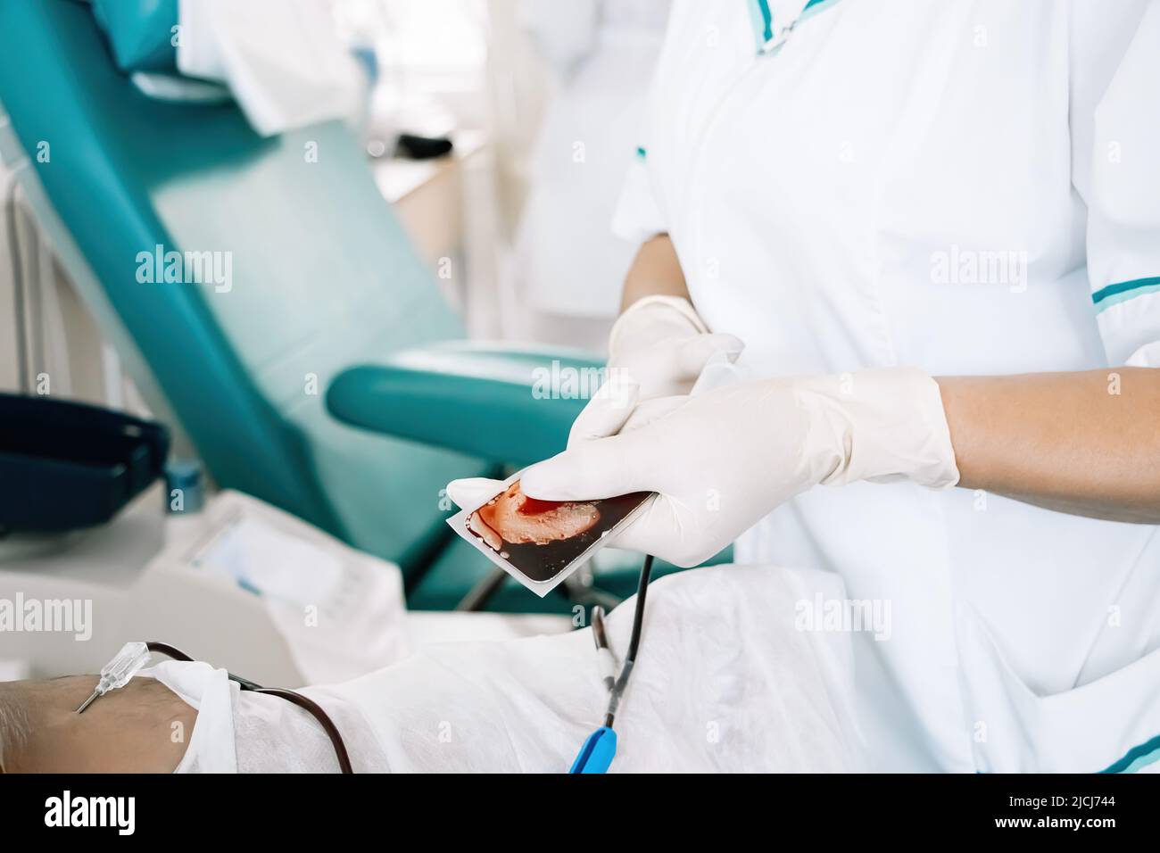 Nurse is holding blood bag in her hands. International Blood Donation Day. Process of blood transfusion in medical hospital. Stock Photo