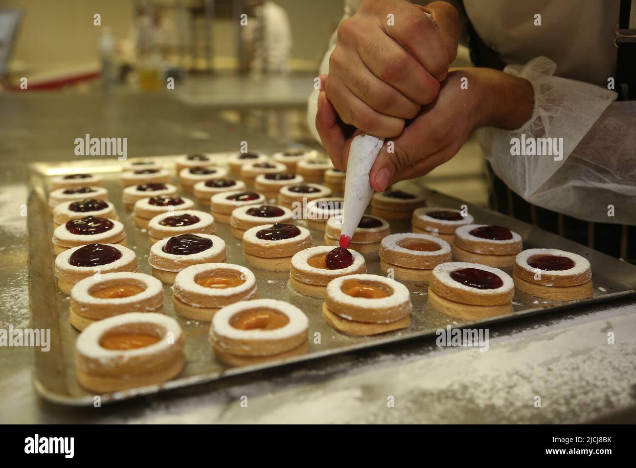 Chef making 'Mini Tartlets' on the bakery shop table. Stock Photo