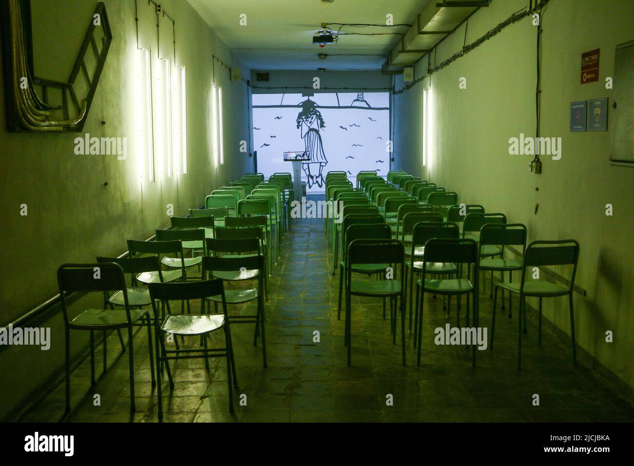 Tirana, Albania - 29.07.2017: Chairs standing in the row in green light in the meeting hall of the Tirana nuclear bunker in city center transformed in Stock Photo