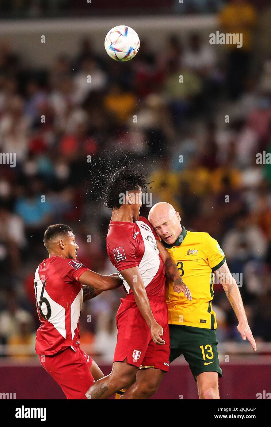 Doha, Qatar. 13th June, 2022. Aaron Mooy (R) of Australia vies with Renato Tapia (C), Christofer Gonzales of Peru during the FIFA World Cup 2022 intercontinental play-offs match between Australia and Peru at the Ahmed bin Ali Stadium, Doha, Qatar, June 13, 2022. Credit: Wang Dongzhen/Xinhua/Alamy Live News Stock Photo