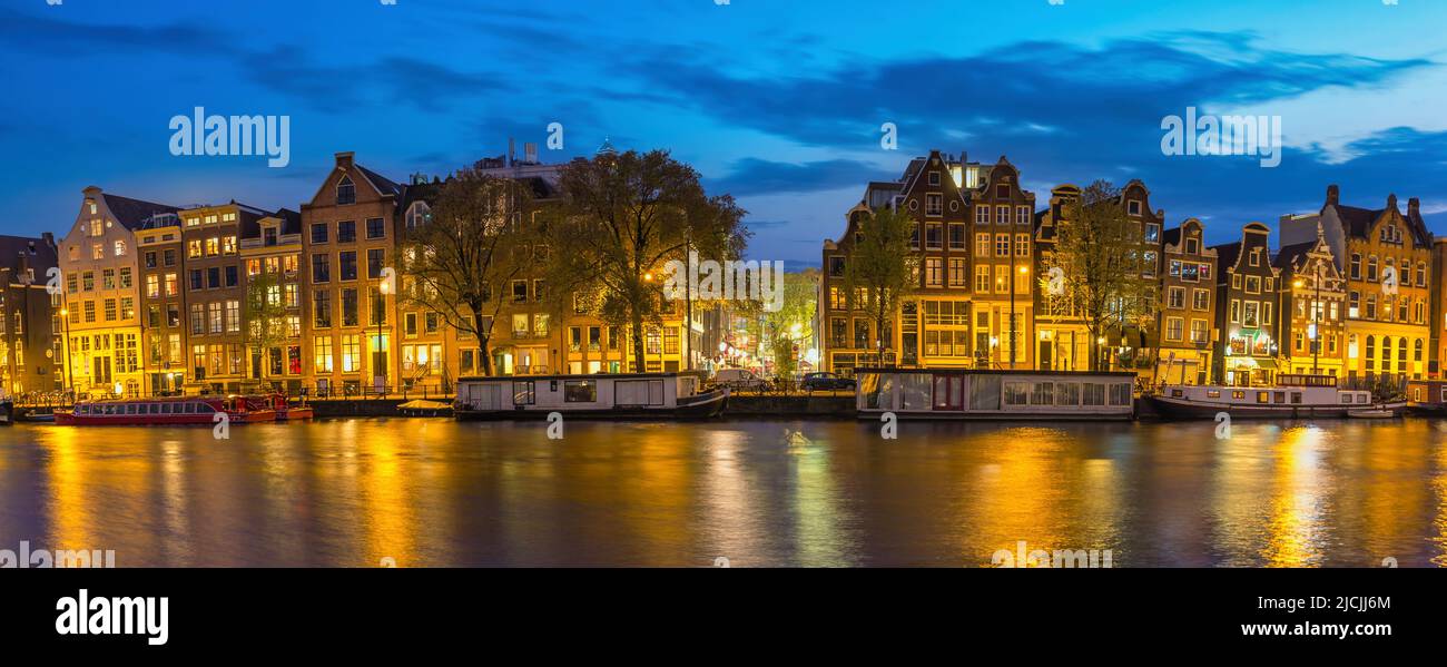 Amsterdam Netherlands, night panorama city skyline of Dutch house at canal waterfront Stock Photo