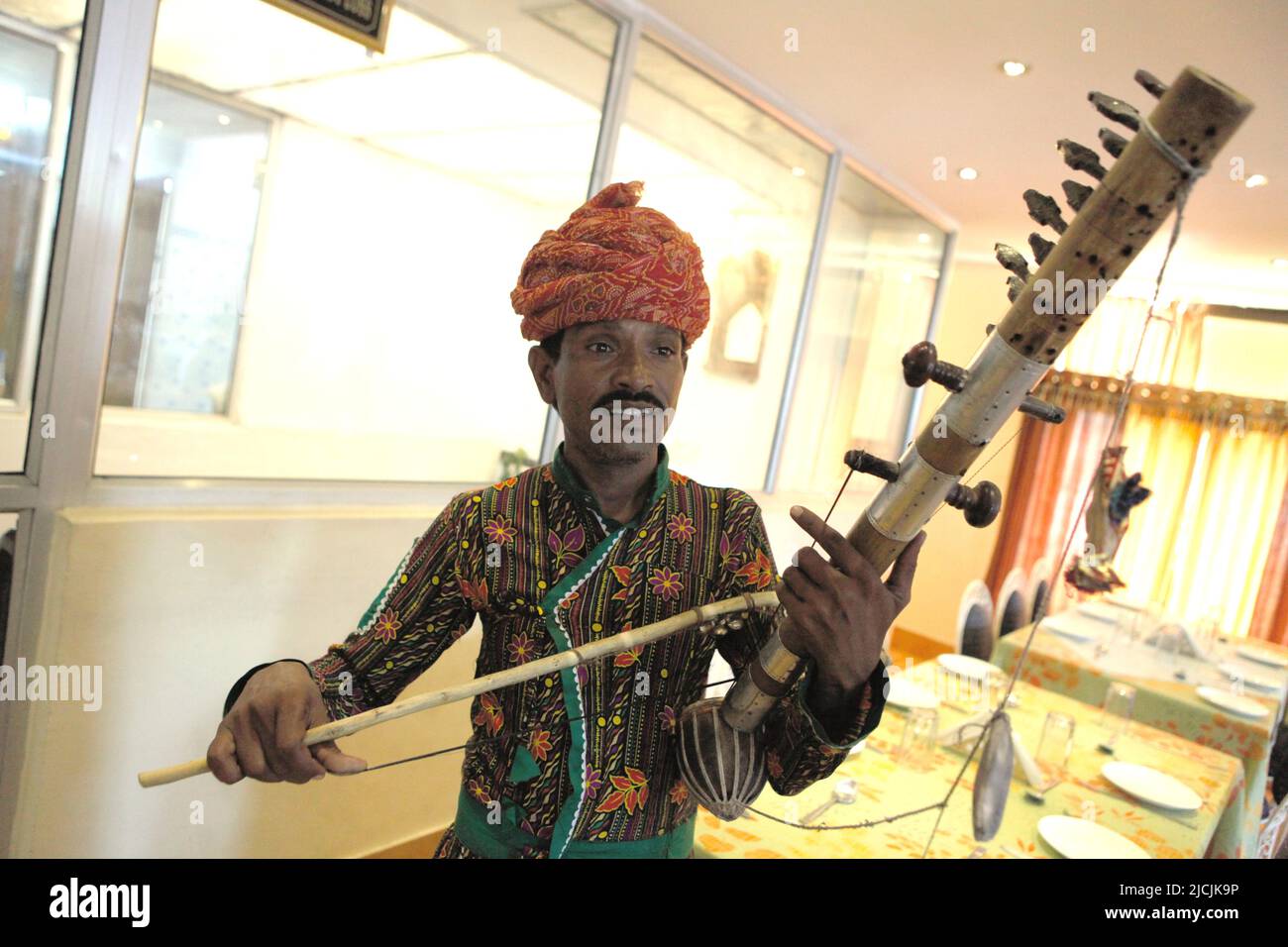 A man playing traditional ravanahatha stringed instrument at a