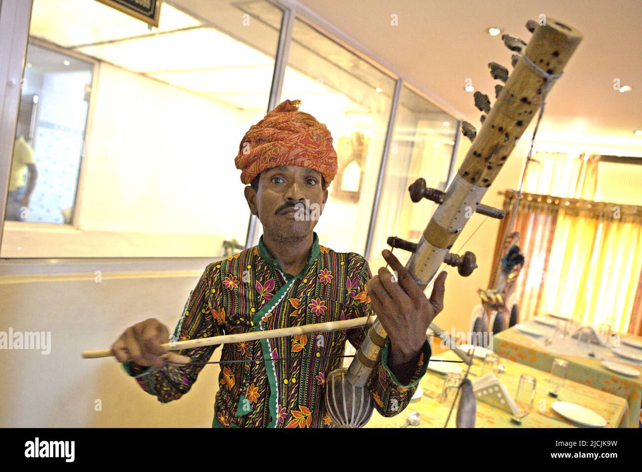 A man playing traditional ravanahatha stringed instrument at a