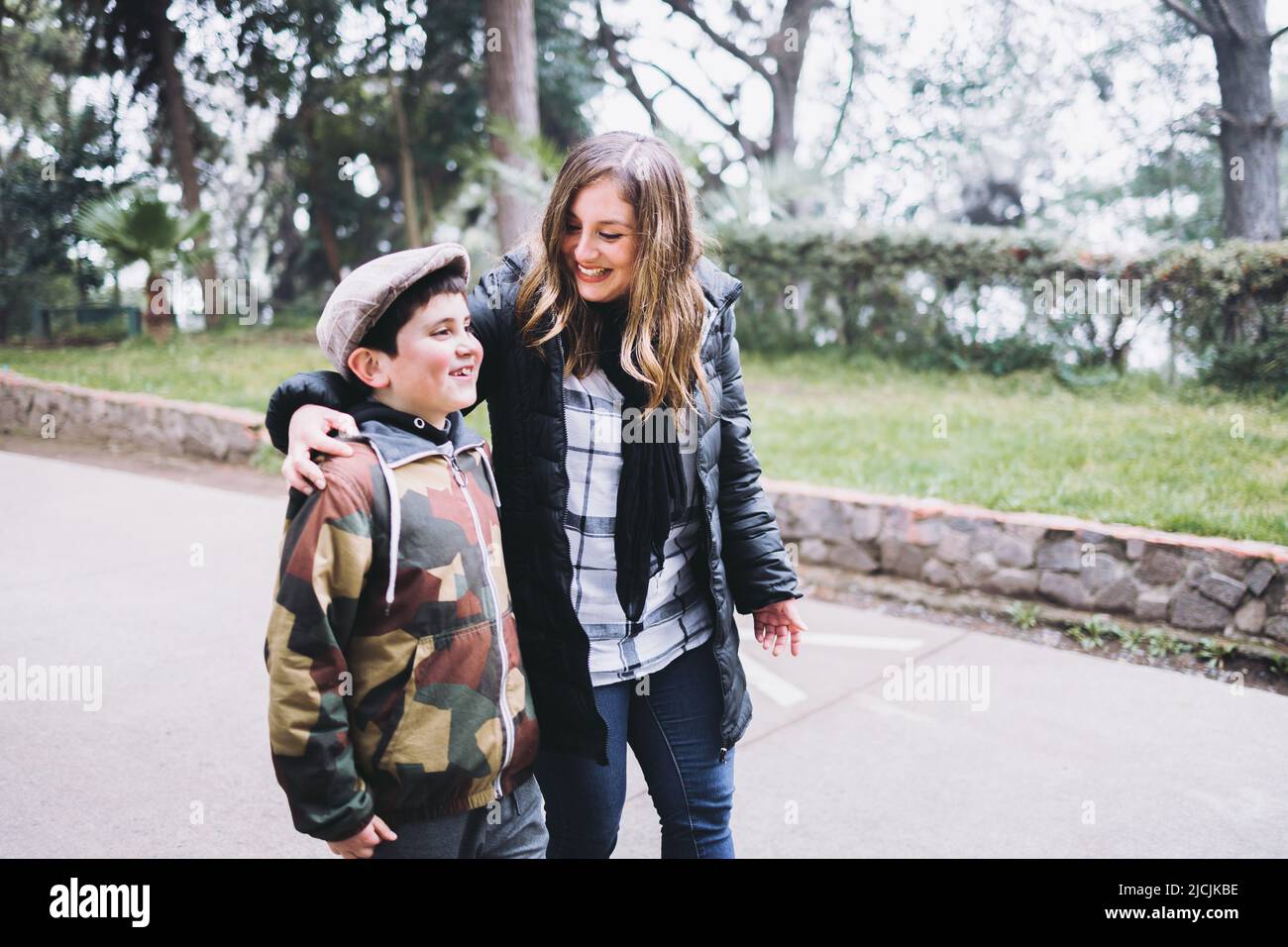 Single mother with her young son walking in the park. Single parent family Stock Photo