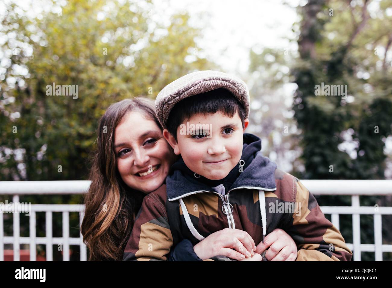 Single mother hugging her young son in the park. Single parent family Stock Photo