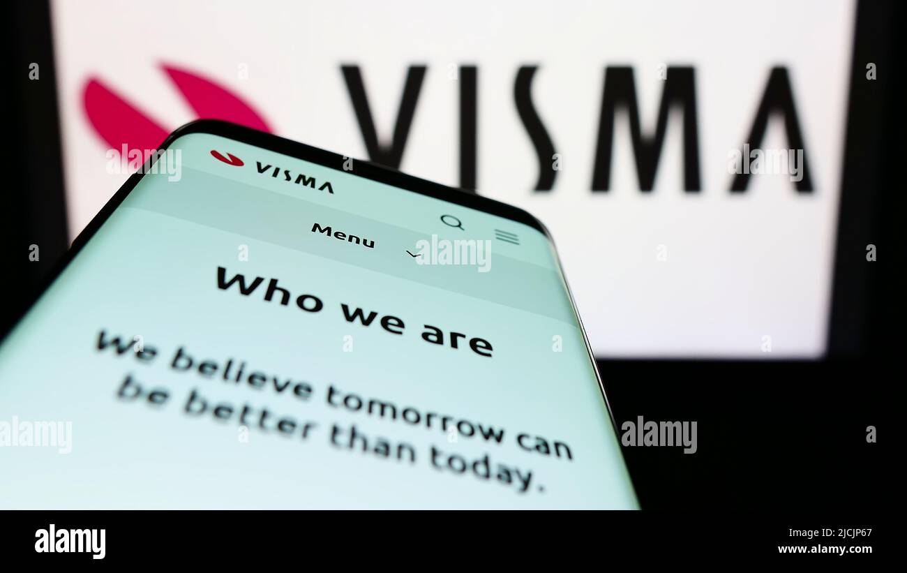 Smartphone with webpage of Norwegian software company Visma AS on screen in front of business logo. Focus on top-left of phone display. Stock Photo