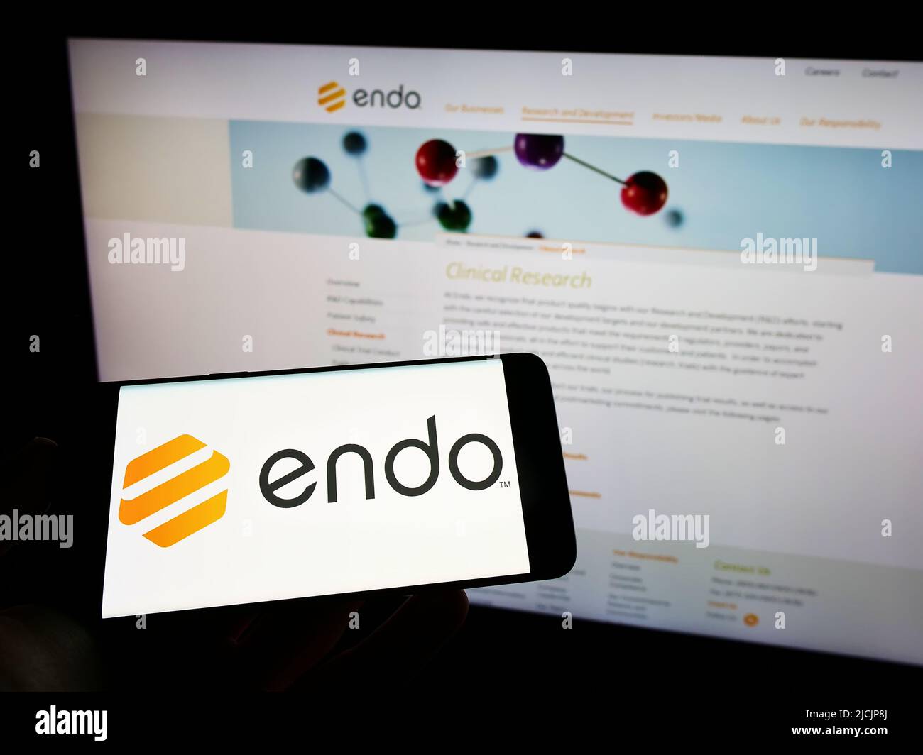 Person holding mobile phone with logo of pharmaceutical company Endo