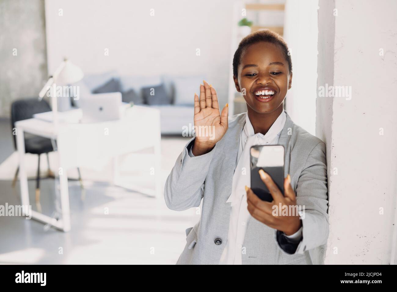 African American woman works via video communication from smartphone with colleagues. working on a project. Business financial concept. Stock Photo