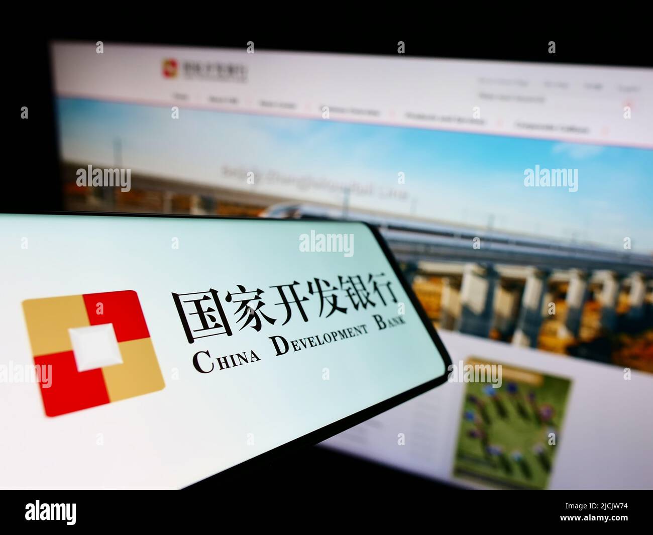 Smartphone with logo of China Development Bank (CDB) on screen in front of website. Focus on center-left of phone display. Stock Photo